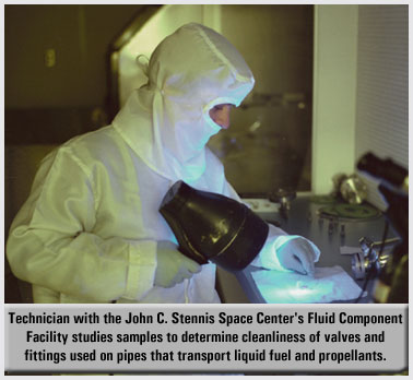 Photo of a worker checking a surface with a UV light.