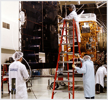 Photo of workers and payload in a cleanroom.