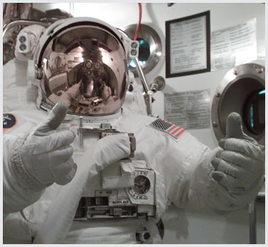 Astronaut in space suit giving a thumbs up signal.